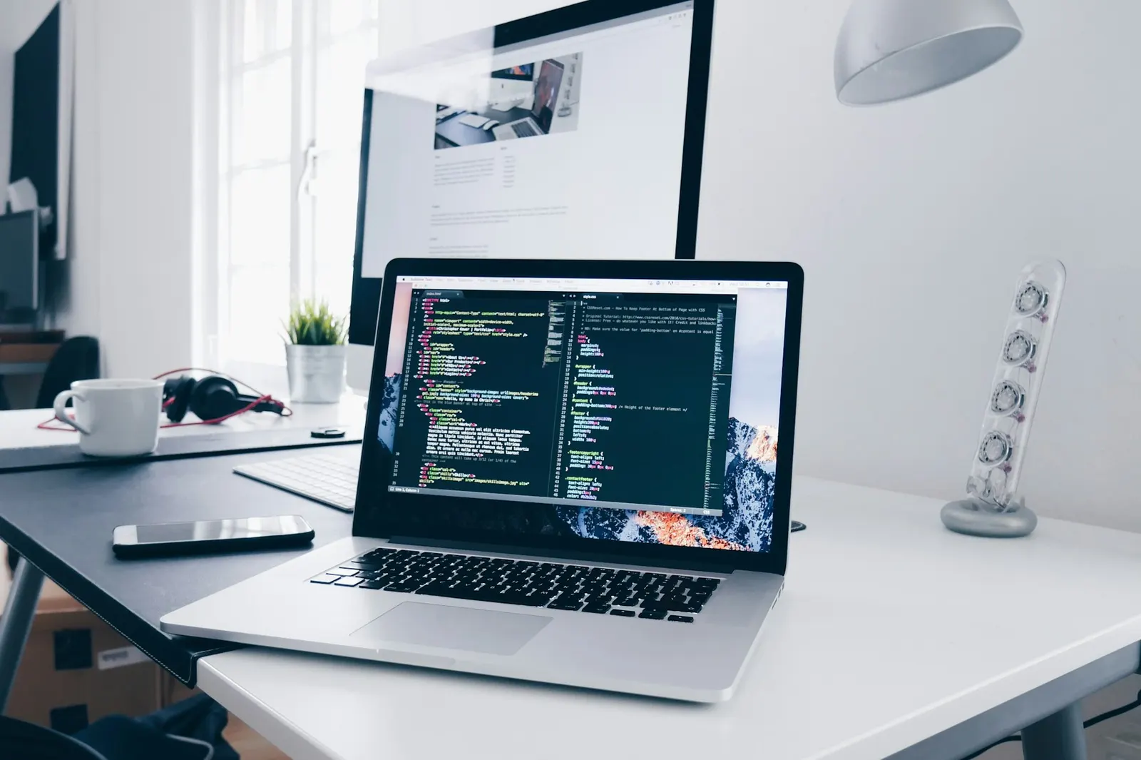 A laptop with code on a desk