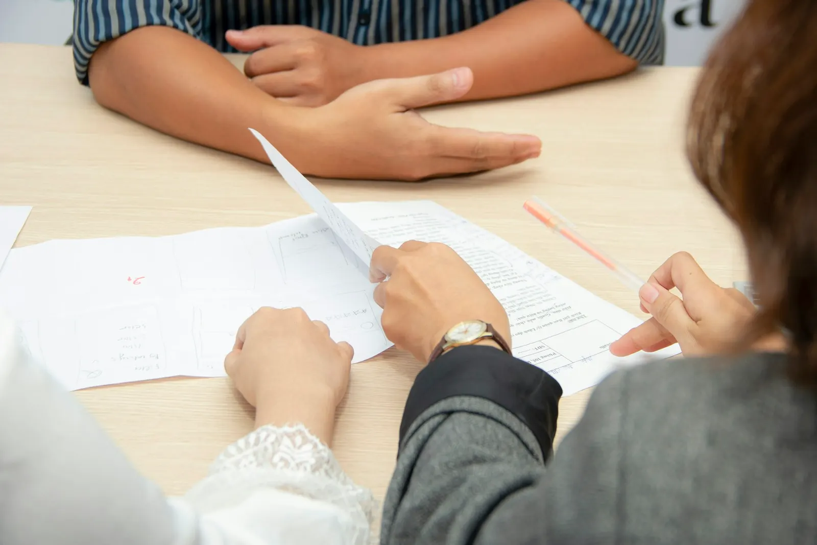 Hands reviewing printed documents
