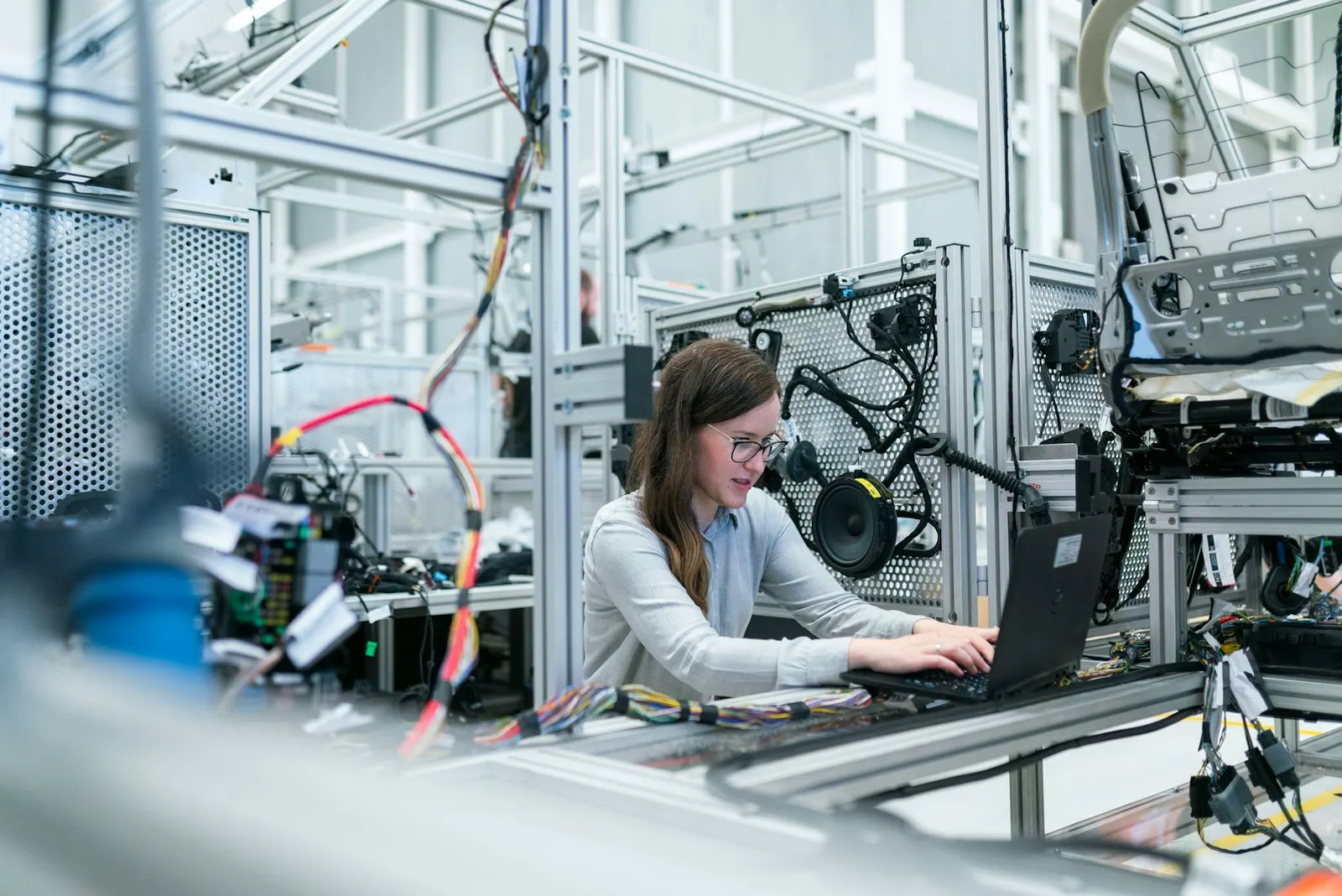 An engineer working with a laptop on a factory floor