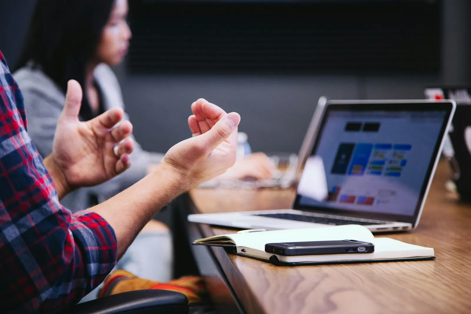 Hands gesturing over a laptop during a working session
